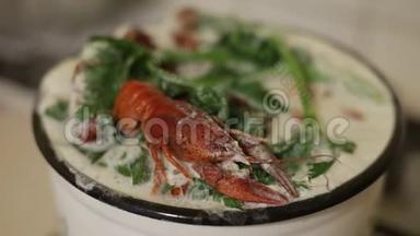 用牛奶和芹菜在锅里煮小龙虾。 Ð锅里煮熟的红色小龙虾。 特写镜头。